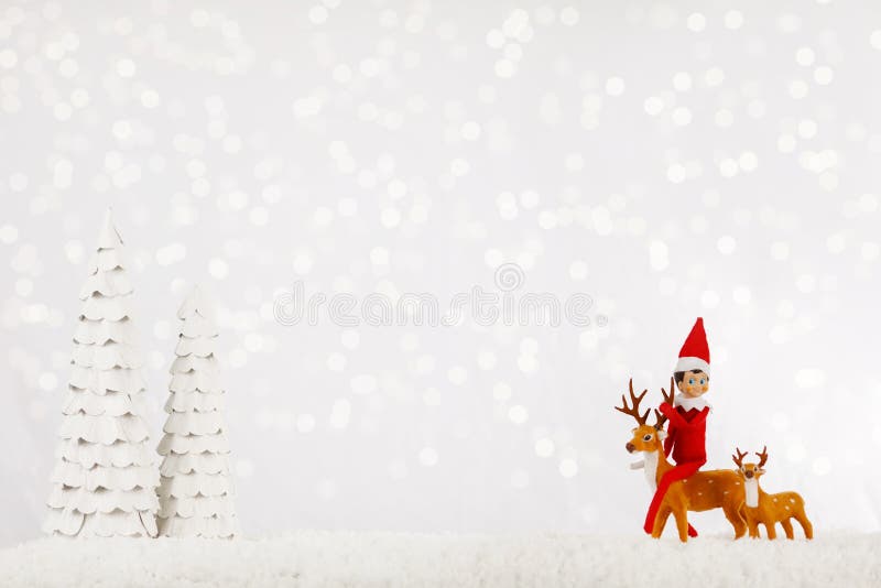 Weihnachtself Versteckt von Bäumen auf einem Schneeschlitten
