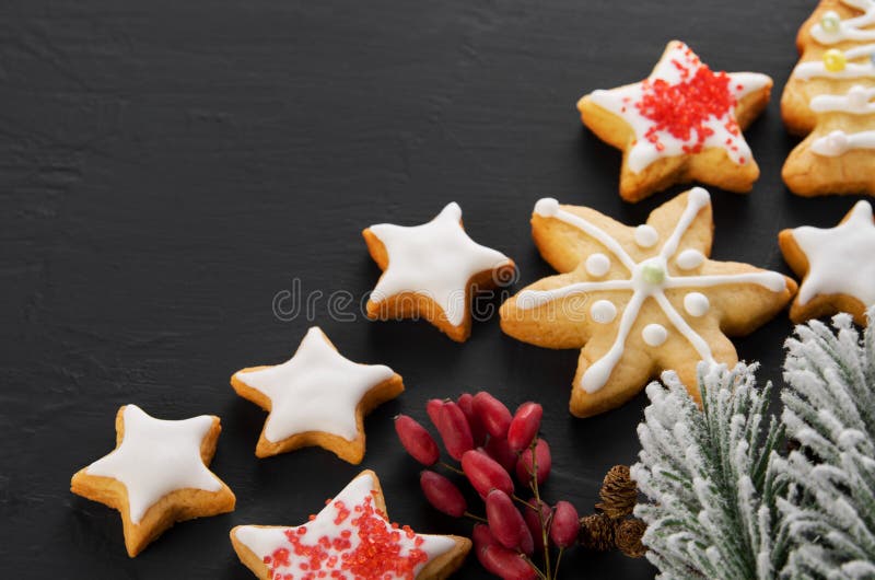 Weihnachtsfichtenzweig, hausgemachte Sternenkekse mit Eis auf schwarzem Hintergrund, Kopierraum stockfotografie Weihnachtsfichtenzweig, hausgemachte Sternenkekse mit Eis auf schwarzem Hintergrund, Kopierraum stockfotografie