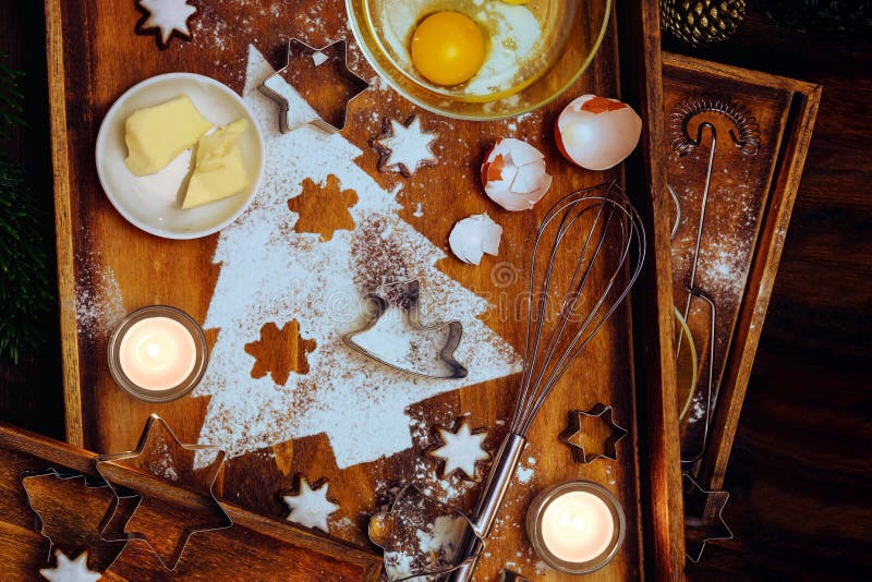 Weihnachtsgebäck, Tannenbaum aus Mehl, Butter, Sternen aus Ei und Zimt, Utensilien und Kerzen aus warmbraunem Holz stockbild Weihnachtsgebäck, Tannenbaum aus Mehl, Butter, Sternen aus Ei und Zimt, Utensilien und Kerzen aus warmbraunem Holz stockbild