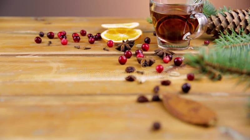 Weihnachtsglühwein mit Zimt, Gewürzen und orange Scheiben auf einem hölzernen Hintergrund