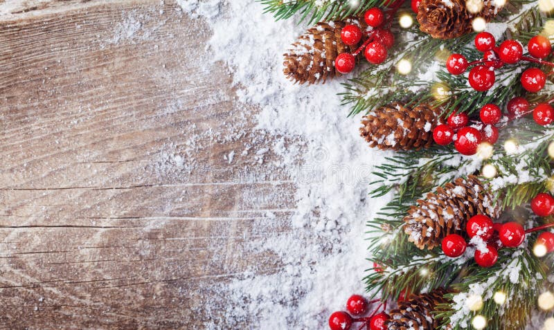 Weihnachtshintergrund mit schneebedeckten Tannenzweigen, Kegeln und bokeh Lichtern Feiertagsfahne oder -karte