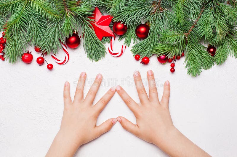 Weihnachtskarte mit grünem Xmas-Tannenverzweiger, roten Holly-Beeren, Baubles und kleinen Girl-Händen mit weißem Hintergrund stockfoto Weihnachtskarte mit grünem Xmas-Tannenverzweiger, roten Holly-Beeren, Baubles und kleinen Girl-Händen mit weißem Hintergrund stockfoto