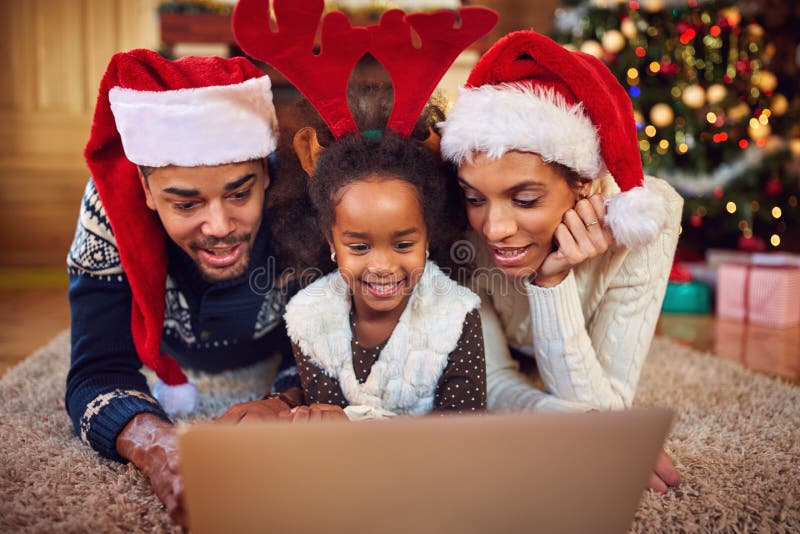 Weihnachtskaufende on-line-Familie, die auf Computer surft lizenzfreie stockbilder Weihnachtskaufende on-line-Familie, die auf Computer surft lizenzfreie stockbilder