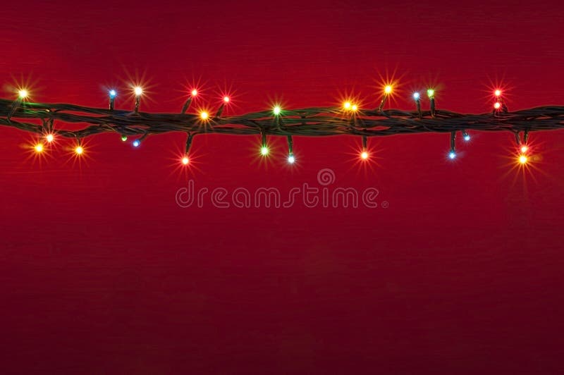 Christmas lights on red background. Multicolored lights background. Abstract light. Spot light. Colorful light background. Border multicolored light. Christmas lights on red background. Multicolored lights background. Abstract light. Spot light. Colorful light background. Border multicolored light.