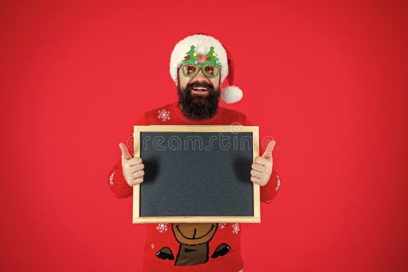 Weihnachtsmann Bartmann in Hut und Weihnachtspulli halten Xmas Werbung für neuen Winterurlaub 2024 Jahr isoliert auf rot stockfotos