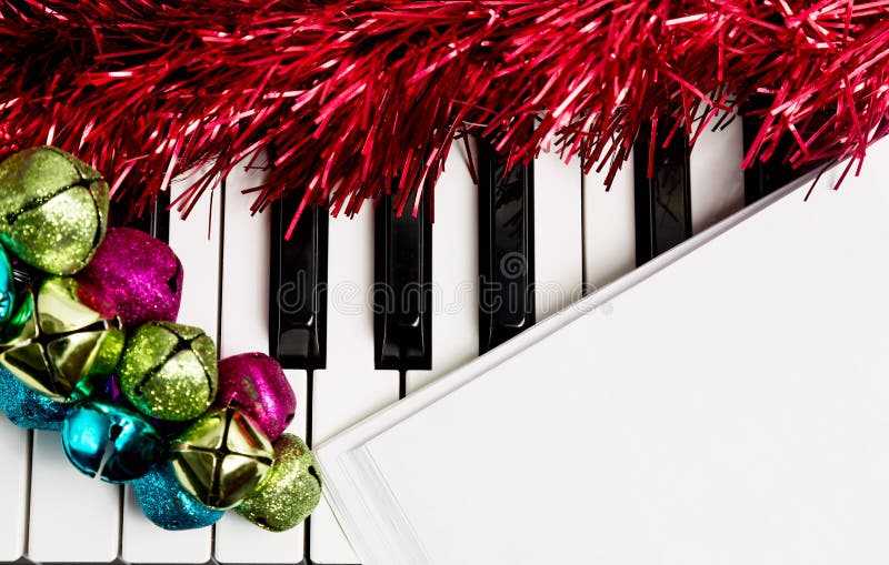 Weihnachtsmusikkonzept Leeres Papier auf dem Klavier mit Klingelglocken und rotem Lametta lizenzfreies stockfoto Weihnachtsmusikkonzept Leeres Papier auf dem Klavier mit Klingelglocken und rotem Lametta lizenzfreies stockfoto