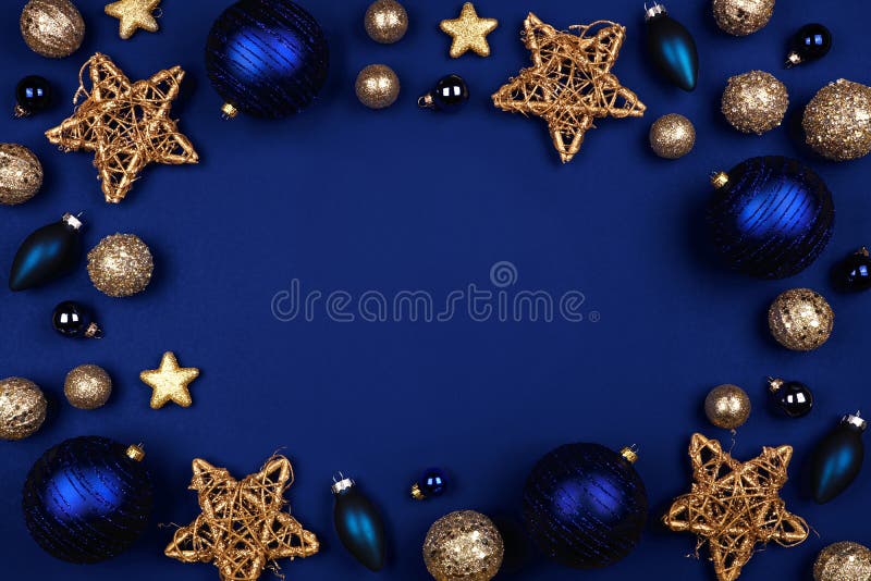 Weihnachtsrahmen für dunkelblaue und goldene Ziergegenstände, oben auf blauem Hintergrund lizenzfreies stockfoto