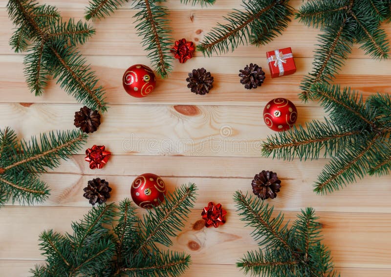 Weihnachtsrahmen gemacht von den Tannenzweigen, von den Kiefernkegeln, von den Geschenkbögen und von den roten Bällen stockfotografie Weihnachtsrahmen gemacht von den Tannenzweigen, von den Kiefernkegeln, von den Geschenkbögen und von den roten Bällen stockfotografie
