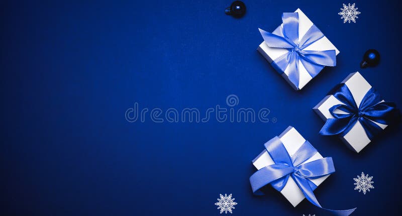 Weihnachtsverkauf. Weiß Geschenk mit blauen Bällen des cyan-blauen Bogens und Winterbaum in Weihnachtsdekoration auf azurblauem Hi stockfotografie