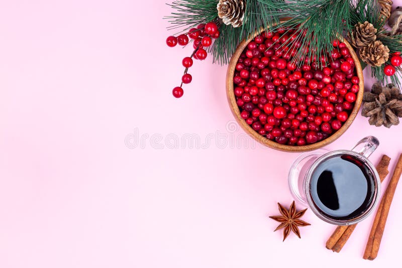Weihnachtskomposition mit Kiefernsekulle aus frischem Cranberglas aus Glühwein Zimt und Anisstar auf rosa Hintergrund stockfotografie