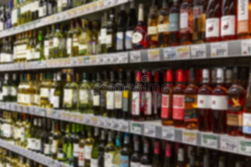 Weinflaschen auf Regalen in einem Geschäft. großes Sortiment Alkohol. verschwommen stockfotografie