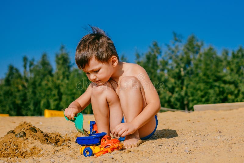 Weinig gelooide jongen die op een zandig strand spelen royalty-vrije stock afbeelding Weinig gelooide jongen die op een zandig strand spelen royalty-vrije stock afbeelding