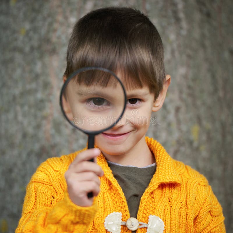 Weinig gelukkige jongen met vergrootglas stock foto Weinig gelukkige jongen met vergrootglas stock foto