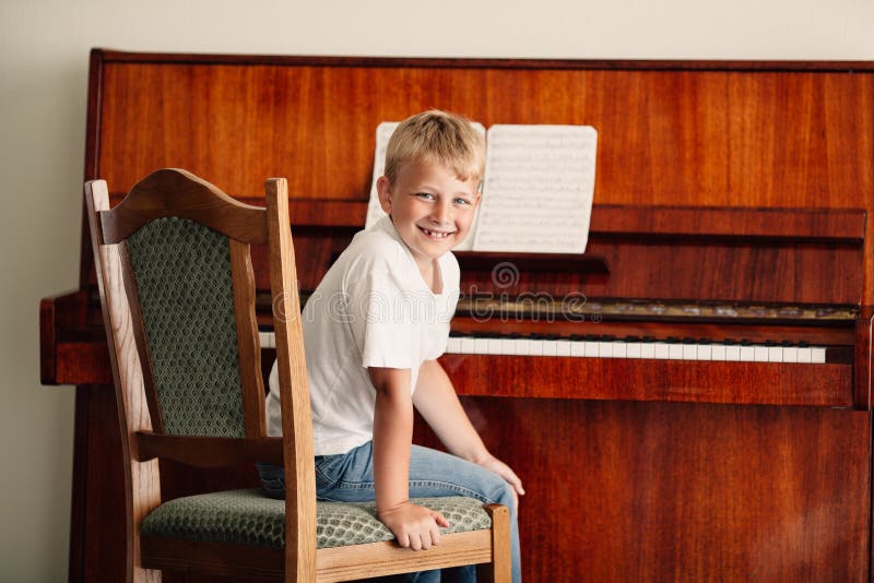 Weinig gelukkige piano van jongensspelen royalty-vrije stock foto's Weinig gelukkige piano van jongensspelen royalty-vrije stock foto's