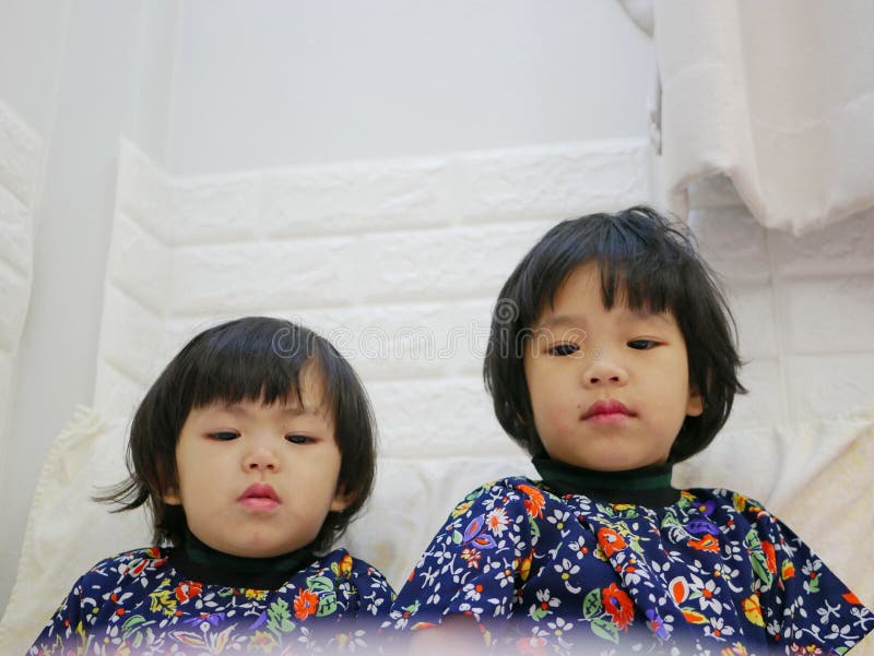 Weinig gezichten van babymeisjes, zusters, 2 en 3 jaar oud, terwijl het letten op/het staren bij een smartphone stock foto's Weinig gezichten van babymeisjes, zusters, 2 en 3 jaar oud, terwijl het letten op/het staren bij een smartphone stock foto's