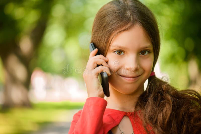 Weinig glimlachend meisje die op celtelefoon spreken royalty-vrije stock afbeelding Weinig glimlachend meisje die op celtelefoon spreken royalty-vrije stock afbeelding
