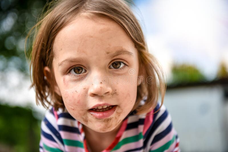 Little kid with dirty face from playing outside in the dirt and mud. Games in the nature, healthy children. Little kid with dirty face from playing outside in the dirt and mud. Games in the nature, healthy children