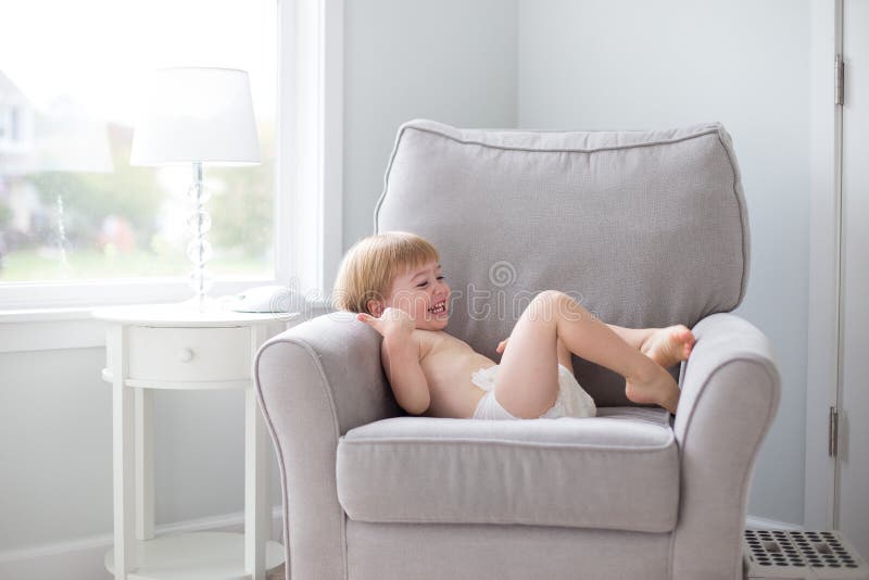 Weinig jongen die als voorzitter lachen die luier dragen royalty-vrije stock afbeeldingen Weinig jongen die als voorzitter lachen die luier dragen royalty-vrije stock afbeeldingen