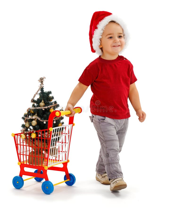 Weinig jongen die boodschappenwagentje met de boom van Kerstmis trekt stock afbeeldingen Weinig jongen die boodschappenwagentje met de boom van Kerstmis trekt stock afbeeldingen