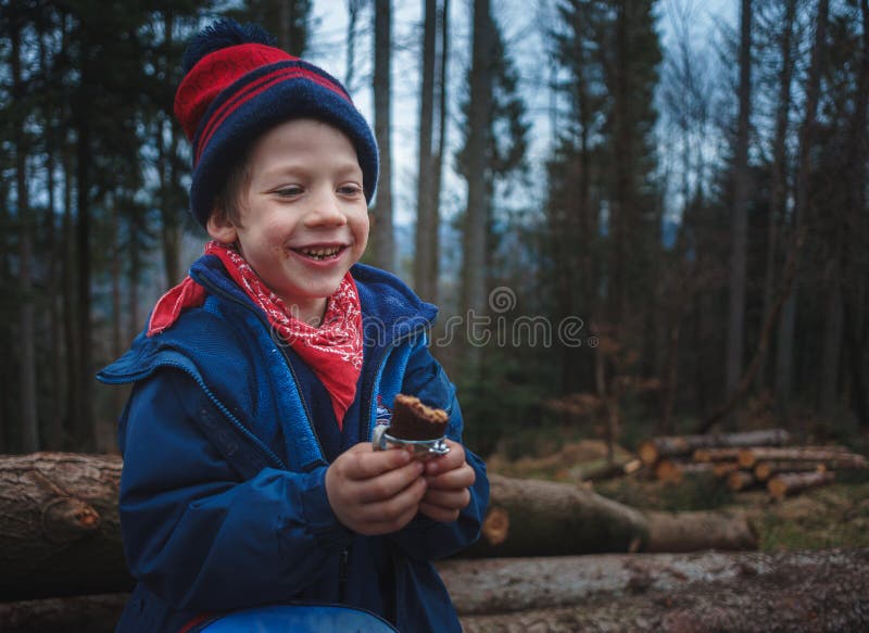 Weinig jongen die een suikergoedbar op een berg bosreis eten royalty-vrije stock fotografie Weinig jongen die een suikergoedbar op een berg bosreis eten royalty-vrije stock fotografie