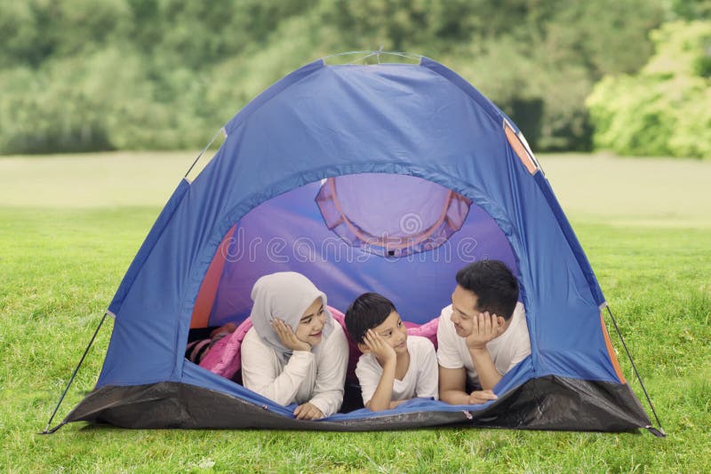Weinig jongen die met zijn ouders in het bos kamperen stock afbeelding Weinig jongen die met zijn ouders in het bos kamperen stock afbeelding