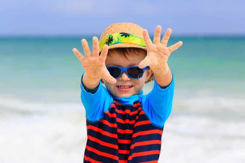 Weinig jongen die pret op tropisch strand hebben royalty-vrije stock foto Weinig jongen die pret op tropisch strand hebben royalty-vrije stock foto