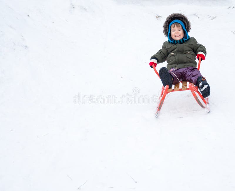 Weinig jongen die van een arrit genieten Kind het sledding Peuterjong geitje die een slee berijden stock afbeelding Weinig jongen die van een arrit genieten Kind het sledding Peuterjong geitje die een slee berijden stock afbeelding