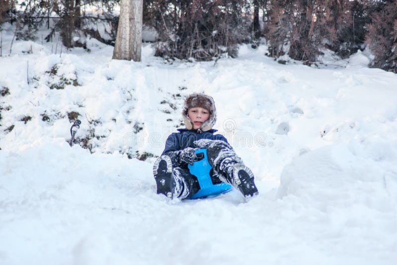 Weinig jongen die van een arrit genieten Kind het sledding Peuterjong geitje die een slee berijden De kinderen spelen in openluch royalty-vrije stock afbeelding Weinig jongen die van een arrit genieten Kind het sledding Peuterjong geitje die een slee berijden De kinderen spelen in openluch royalty-vrije stock afbeelding