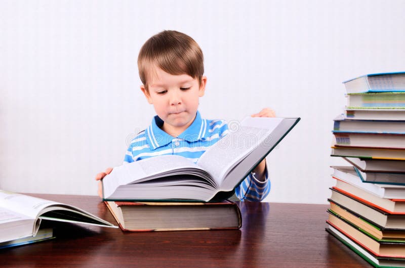 Weinig jongen opent een groot boek en het onderzoeken van het royalty-vrije stock afbeelding Weinig jongen opent een groot boek en het onderzoeken van het royalty-vrije stock afbeelding