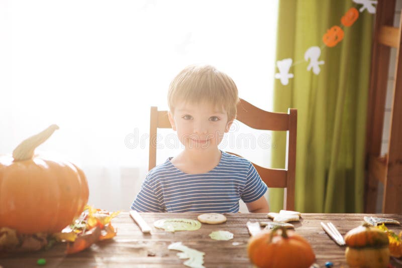 Weinig jongen in piraatkostuum op Halloween-truc of behandelt Jonge geitjes die pompoenlantaarn snijden De kinderen vieren Hallow royalty-vrije stock fotografie Weinig jongen in piraatkostuum op Halloween-truc of behandelt Jonge geitjes die pompoenlantaarn snijden De kinderen vieren Hallow royalty-vrije stock fotografie