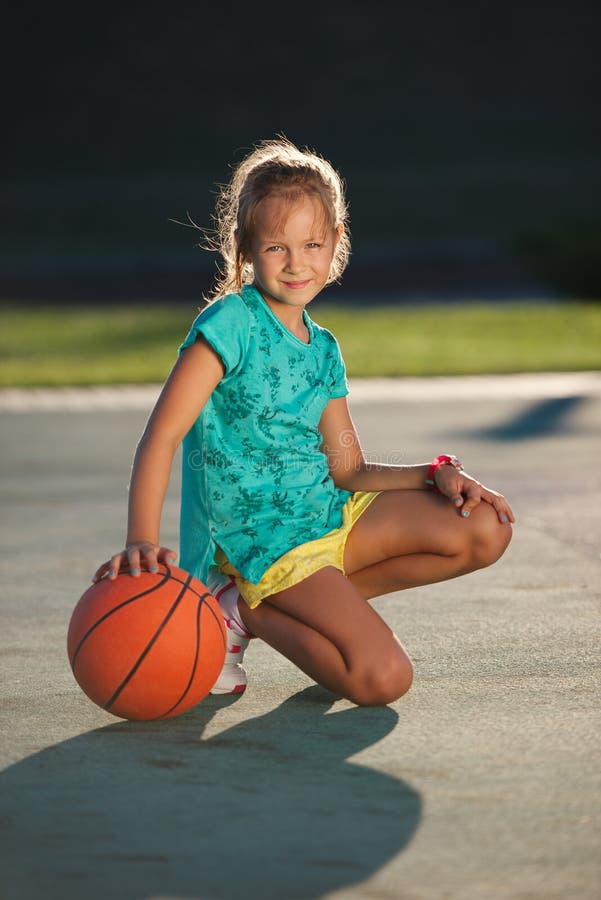 Weinig leuk meisjes speelbasketbal in openlucht stock fotografie Weinig leuk meisjes speelbasketbal in openlucht stock fotografie