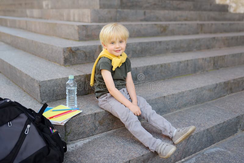Weinig studentenzitting op trap dichtbij het schoolgebouw Terug naar School stock foto's Weinig studentenzitting op trap dichtbij het schoolgebouw Terug naar School stock foto's