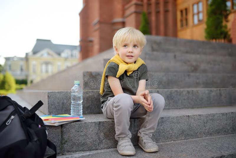 Weinig studentenzitting op trap dichtbij het schoolgebouw Terug naar School royalty-vrije stock afbeeldingen Weinig studentenzitting op trap dichtbij het schoolgebouw Terug naar School royalty-vrije stock afbeeldingen