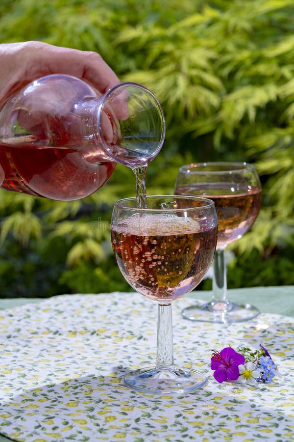 Weinkaraffe und -gläser mit kaltem rosafarbenem Wein und wilden Blumen am sonnigen Tag des Sommers stockfotografie Weinkaraffe und -gläser mit kaltem rosafarbenem Wein und wilden Blumen am sonnigen Tag des Sommers stockfotografie