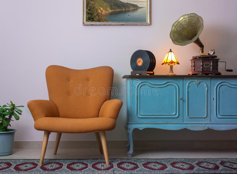 Weinleseinnenraum des Retro- orange Lehnsessels, der hölzernen hellblauen Anrichte der Weinlese, des alten Plattenspielergrammoph