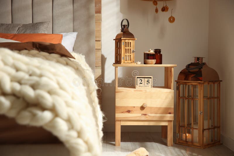 Weinleselaterne und -kerzen auf Holz nightstand im Schlafzimmer. Inneneinrichtung stockfoto