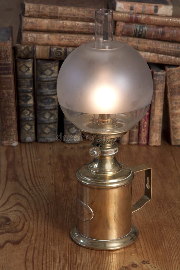 Weinleseschmieröllampe mit Büchern stockfotos Weinleseschmieröllampe mit Büchern stockfotos