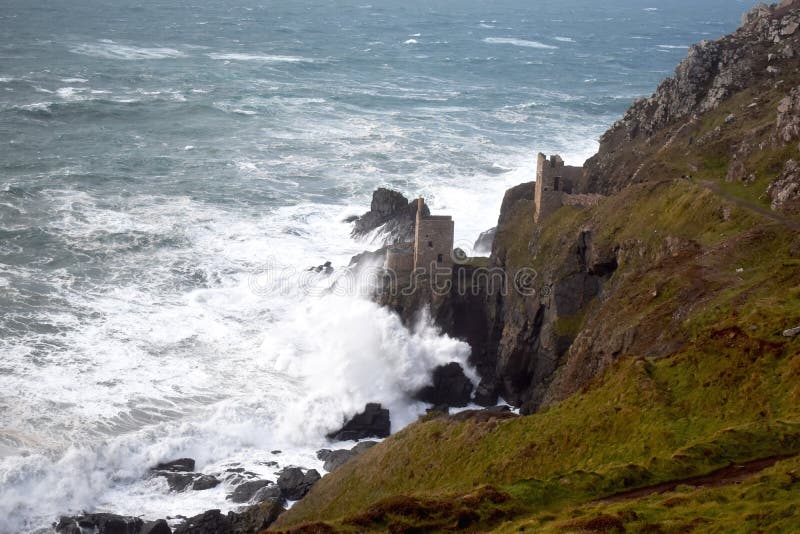 The Crowns are two engine houses perched on the edge of the spectacular West Penwith cliffs. They were once part of the mighty Botallack Mine and are now one of the most recognisable mining landmarks on the Cornish coast. Photographed on an october afternoon during a storm. National Trust now owns the site which was a film location in the BBC series Poldark. The Crowns are two engine houses perched on the edge of the spectacular West Penwith cliffs. They were once part of the mighty Botallack Mine and are now one of the most recognisable mining landmarks on the Cornish coast. Photographed on an october afternoon during a storm. National Trust now owns the site which was a film location in the BBC series Poldark.