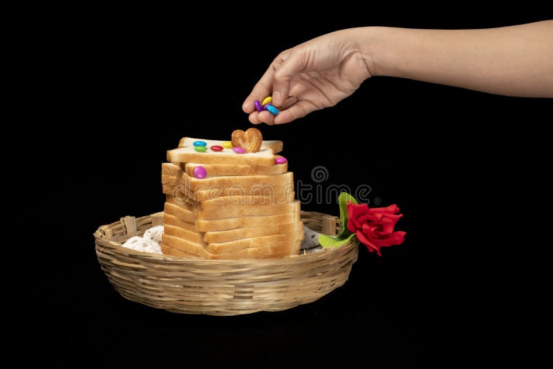 Weißbrotstapel in einer Kistenschale auf dem Oberherz geformten Keks Hand mit Schokolade mit handroter Rose stockfotos