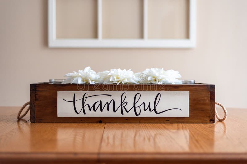 Weiße Blumen in einer rustikalen hölzernen Kiste mit dem Wort dankbar