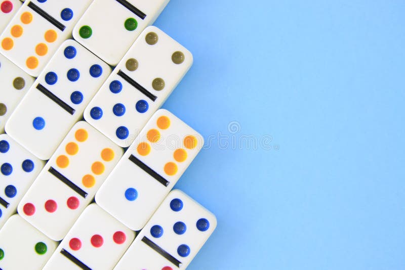 Weiße Dominos mit hell farbigen Punkten auf blauem Hintergrund
