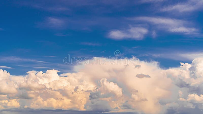 Weiße flaumige Wolken bewegen sich schnell über den blauen Himmel.