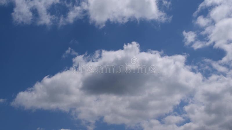 Weiße und graue Wolken bewegen sich in blauen Himmel