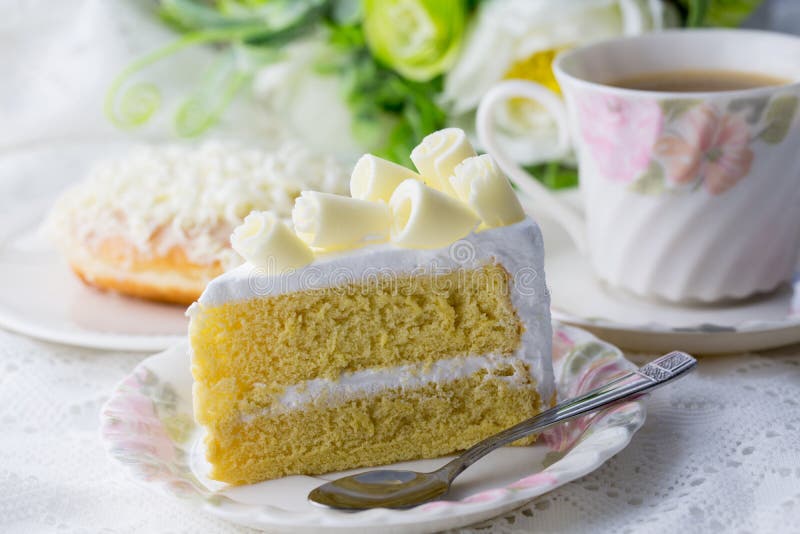 Weißes choclate Kuchen wiyh schöne Schale coffe auf weißer Tabelle und Blume stockfotos Weißes choclate Kuchen wiyh schöne Schale coffe auf weißer Tabelle und Blume stockfotos