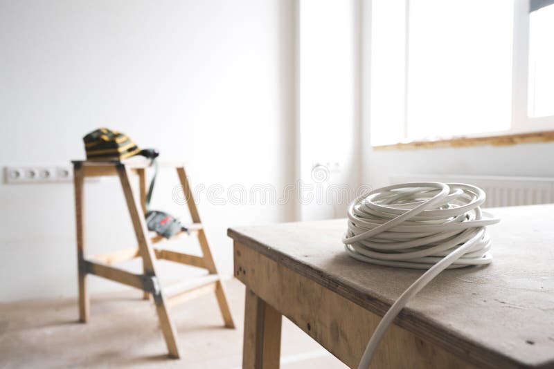 Weißes elektrisches Kabel steht auf der Leiter der Ziege innerhalb der Wohnung und der Reparatur still stockfotos Weißes elektrisches Kabel steht auf der Leiter der Ziege innerhalb der Wohnung und der Reparatur still stockfotos