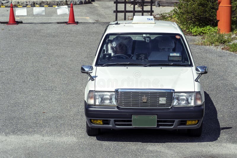 Weißes Retro- japanisches Taxi-Auto in Tokyo, Japan lizenzfreie stockbilder Weißes Retro- japanisches Taxi-Auto in Tokyo, Japan lizenzfreie stockbilder