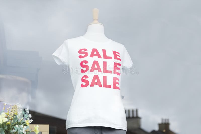 Weißes T-Shirt des roten Verkaufs auf weiblichem Mannequin im Shopfenster lizenzfreies stockbild