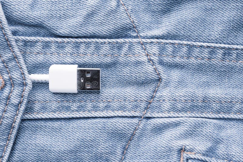 Weißes USB-Kabel in den Jeans stecken ein stockfotografie Weißes USB-Kabel in den Jeans stecken ein stockfotografie