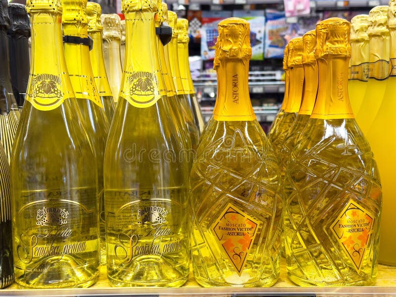 Weißweinflaschen mit glänzender Farbe werden auf der Regale mit gelben Etiketten ausgestellt lizenzfreies stockbild