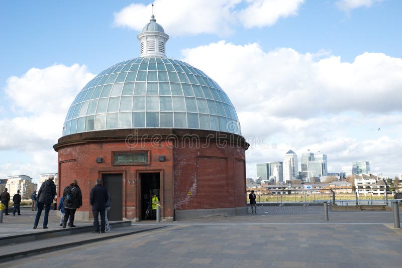 Foot tunnel dome architecture on the riverside of Thames waters in London with Canary Wharf in the background. Foot tunnel dome architecture on the riverside of Thames waters in London with Canary Wharf in the background